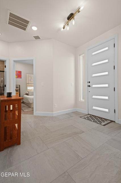 This formal entry space has high ceiling and tile flooring